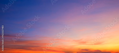 Evening sky background after sundown with dramatic dusk clouds and colorful orange yellow natural light on blue twilight sky, Beautiful summer sunrise panoramic sky backdrop
