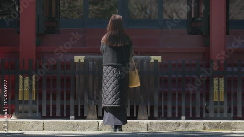 神社で参拝をする女性