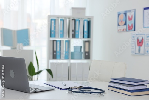 Obraz na płótnie Laptop, stationery and stethoscope on desk in doctor's office w salonie