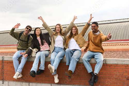 Happy students raising arms and smiling at atocha station