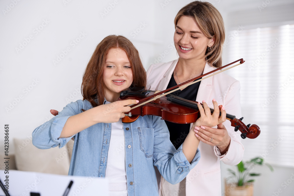 Woman teaching teenage girl to play violin at music lesson Woman teaching teenage girl to play violin at music lesson
