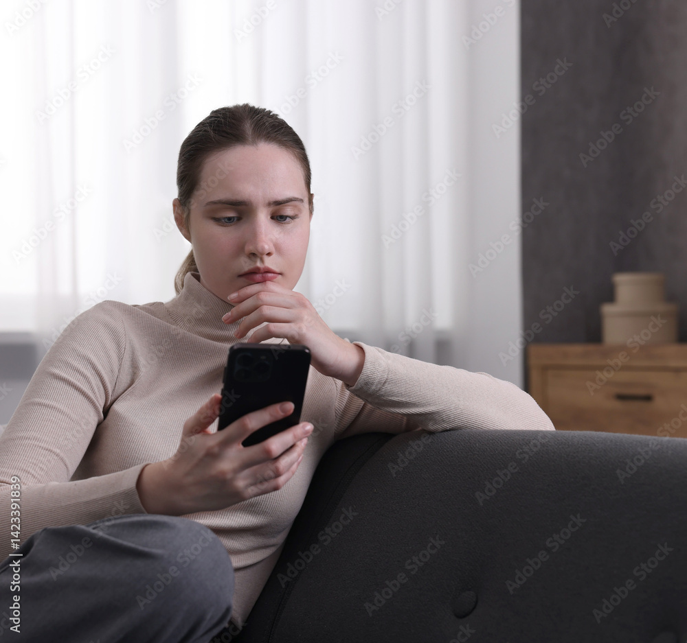 Depressed woman calling hotline for mental health help on sofa at home