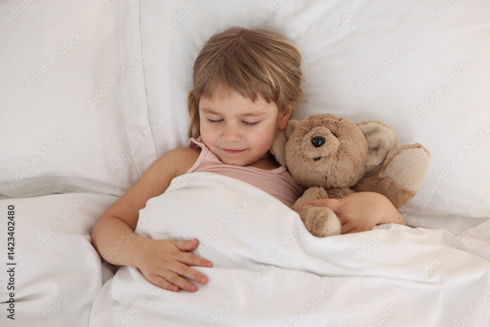 Bedtime. Cute little girl sleeping with teddy bear in bed, above view Bedtime. Cute little girl sleeping with teddy bear in bed, above view