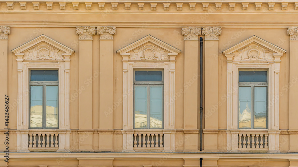 Obraz premium old yellow facade of house with three brown vintage wooden windows in retro italian european style