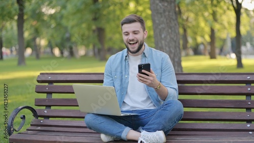 Fototapeta Naklejka Na Ścianę i Meble -  A man relaxing in a park with his laptop.