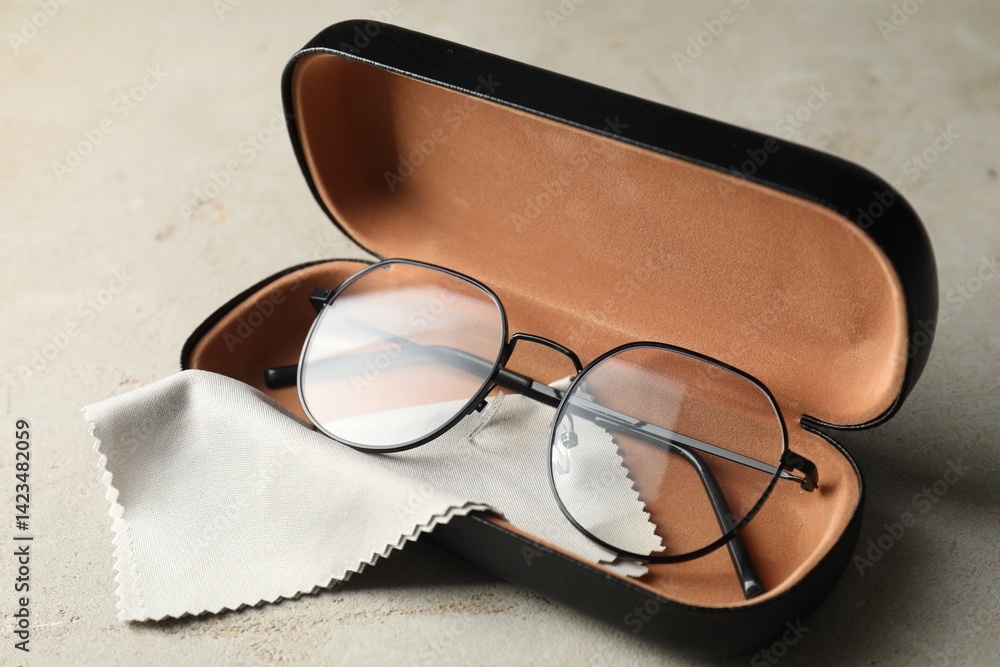 Stylish glasses in case on light table, closeup