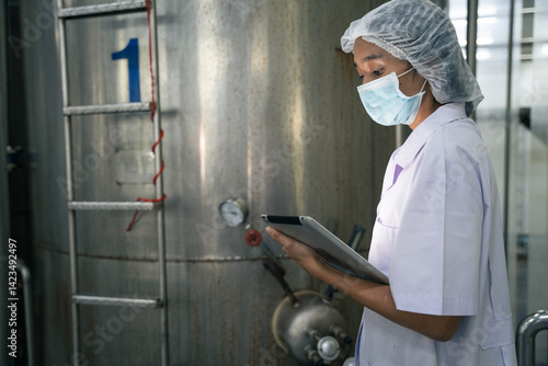A food factory researcher inspecting canned food conveyor belt machine. Worker checking on quality control of production line at food industry