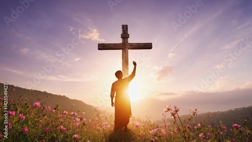 Obraz na płótnie A person silhouetted in front of a cross during sunset, set against a vibrant sky and flowering plants. w salonie