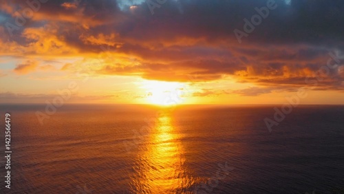 Calm sunset over ocean with clouds in sky.