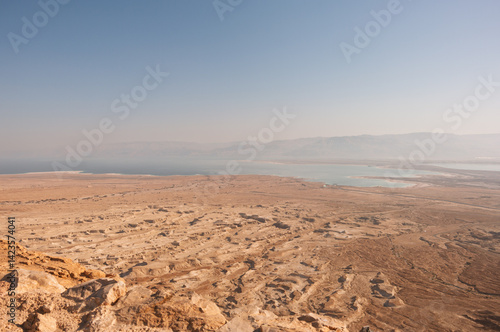 A desert landscape with a blue ocean in the background
