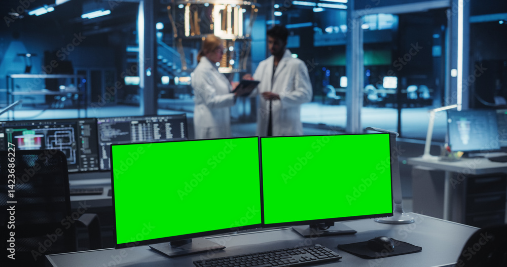Naklejka premium Modern Industrial Office with Desktop Computers with Green Screen Mock Up Displays. Scientific Lab, Engineering Research Center with Quantum Computer and Scientists Working in the Background