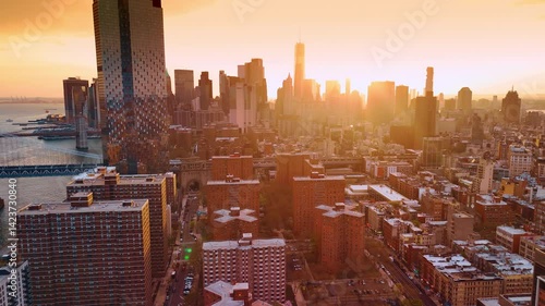 Manhattan view at sunset. City view dazzled by orange light. Aerial perspective on the Manhattan Bridge and Brooklyn Bridge.
