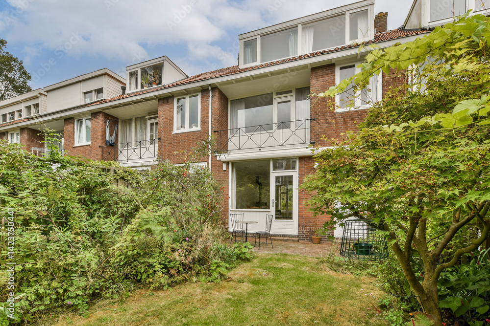 A picturesque view of a residential house nestled amidst vibrant greenery, showcasing harmonious architecture and landscaping.