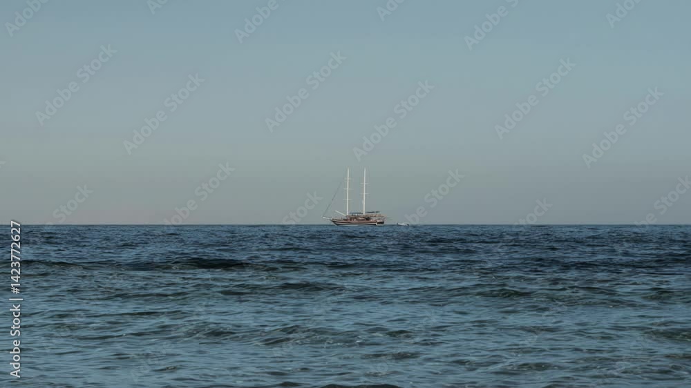 Two-masted sailing ship Brig with lowered sails floats on sea on horizon. Cruise holidays on tourist Brigantine vessel. Pure chill, concept of dream getaway. Extreme Long Wide Shot Two-masted sailing ship Brig with lowered sails floats on sea on horizon. Cruise holidays on tourist Brigantine vessel. Pure chill, concept of dream getaway. Extreme Long Wide Shot