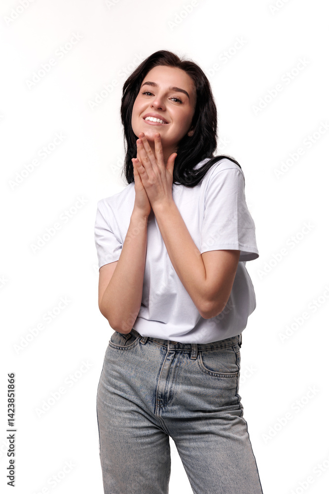 Young woman expressing joy and gratitude in a casual outfit against a white background Young woman expressing joy and gratitude in a casual outfit against a white background