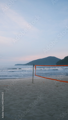 Wallpaper Mural Photo of an empty beach with a volleyball net / beach tennis net, soft pink sky, and ocean waves in the background. Captured right before sunset in Ubatuba, coast of São Paulo. Torontodigital.ca