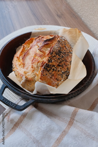 Wallpaper Mural Freshly baked golden sourdough bread in a cast iron pan on a baking sheet. Homemade bread captured in soft early morning light, perfect breakfast vibes. Torontodigital.ca