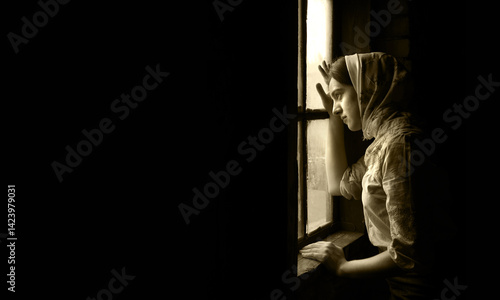 Orthodox devote adult lone worry fail poor holy lady trust ask plead god Jesus Christ peace love old Ukraine history. Cold war young human teen face think life dark home room text space look light sky