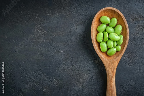 Wooden spoon filled with lima beans 