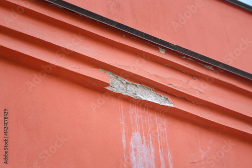 Obraz na płótnie Detailed view of red building with damaged facade, importance of preservation. Damaged facade, weathering and paint peeling. Decaying red wall of building with broken surface, visible cracks w salonie