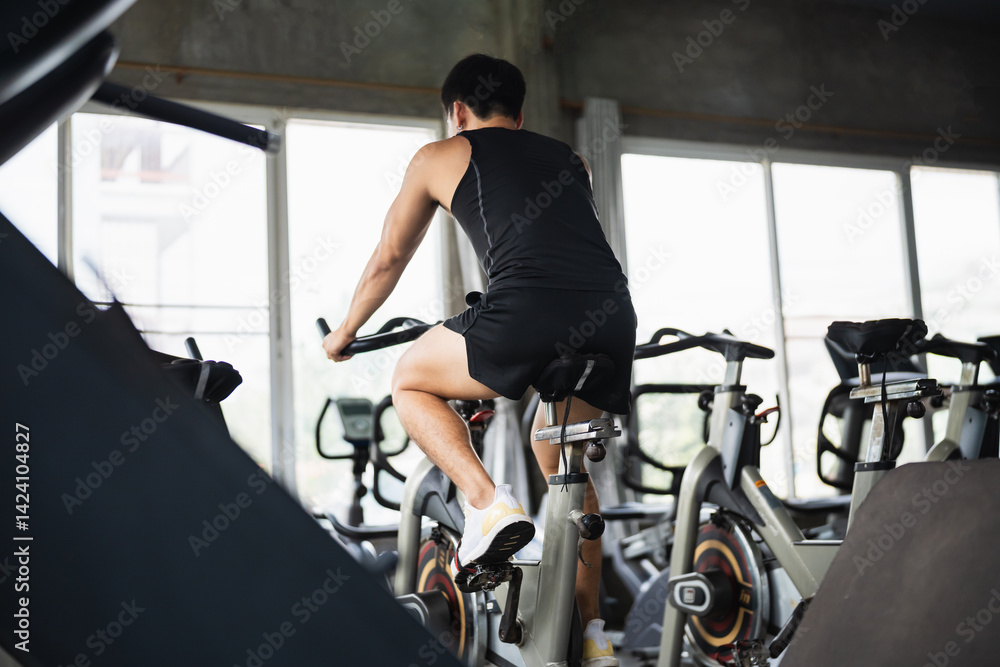 Fitness Enthusiast Engaged in Intense Cardio Workout on Stationary Bicycle in Modern Gym Environment Focusing on Health and Wellness Journey Fitness Enthusiast Engaged in Intense Cardio Workout on Stationary Bicycle in Modern Gym Environment Focusing on Health and Wellness Journey