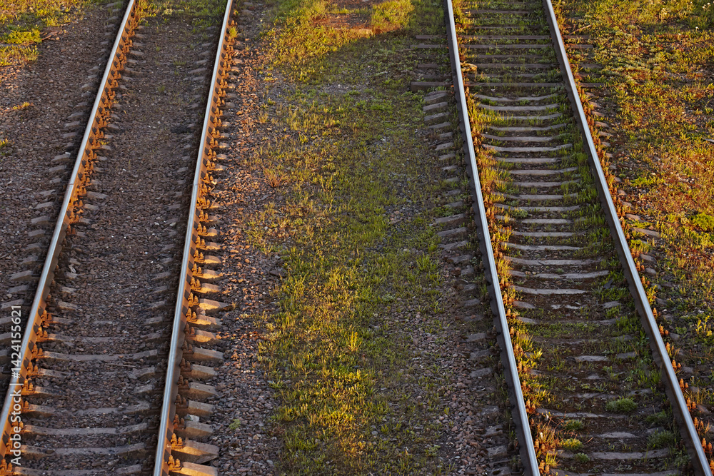 Fototapeta premium Top view: two railway tracks at sunset, close-up
