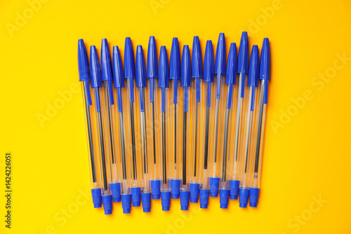 Obraz na płótnie Many ballpoint pens with caps on orange background, flat lay w salonie