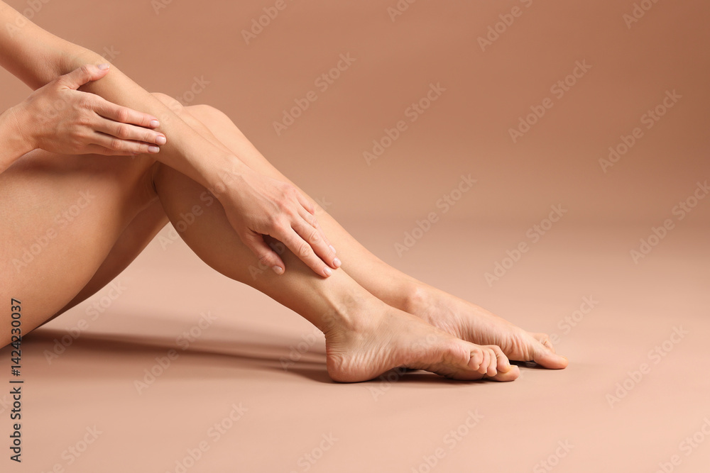 Epilation. Woman showing her legs with smooth soft skin on dark beige background, closeup Epilation. Woman showing her legs with smooth soft skin on dark beige background, closeup