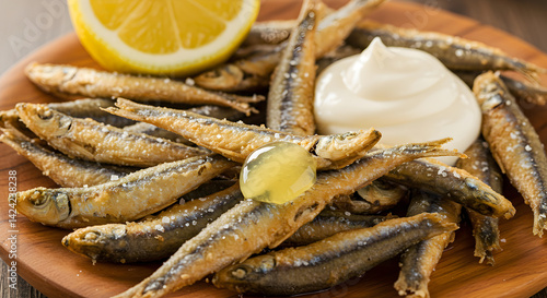 Crispy Fried Anchovies Served With Lemon and Mayonnaise on Wooden Plate