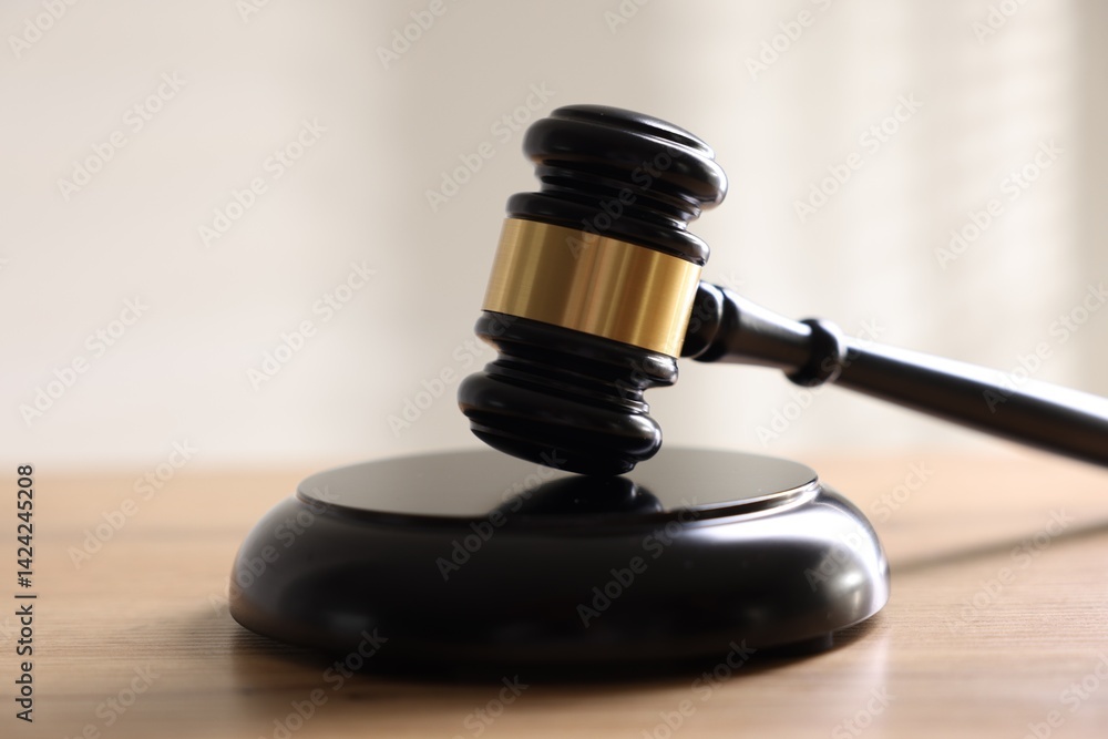 Judge's gavel on wooden table against light background, closeup Judge's gavel on wooden table against light background, closeup
