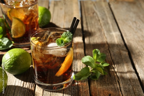 Photography Refreshing Cuba libre cocktail with mint on wooden table