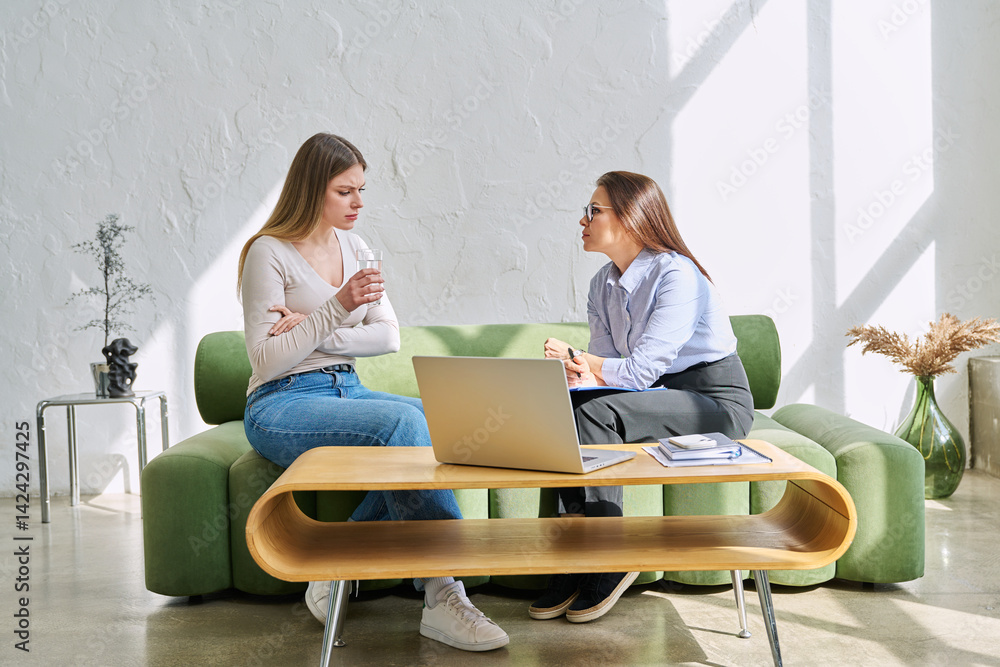 Serious young woman in session in office of professional psychologist, therapist
