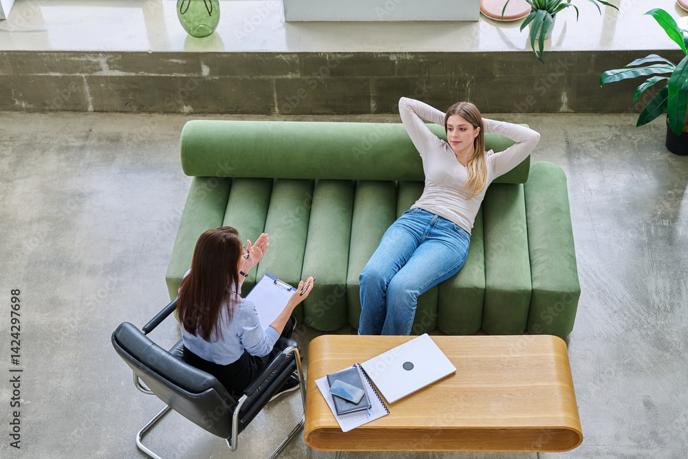 Relaxed young woman lying on sofa in psychologist office at therapy session