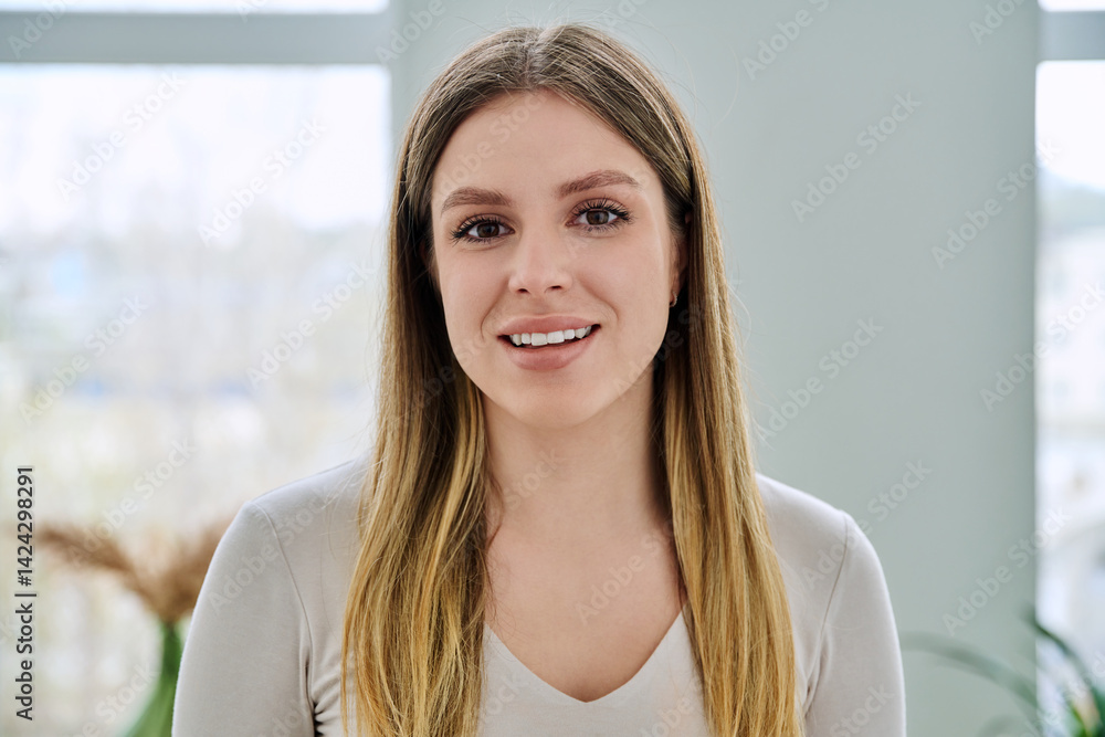 Headshot portrait of young happy woman posing in home