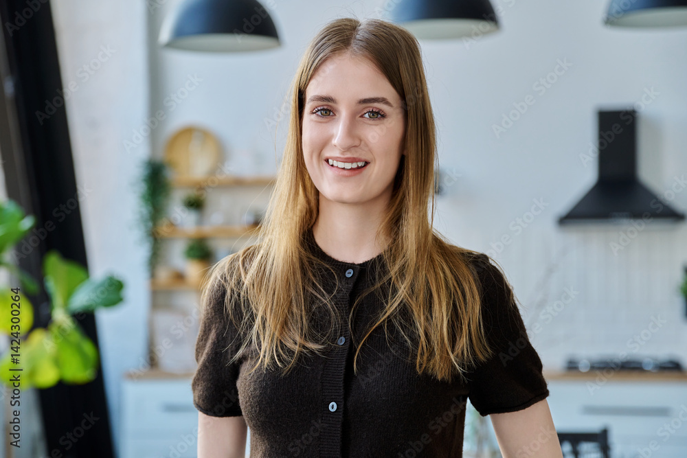 Portrait of beautiful young girl looking at camera, home interior background
