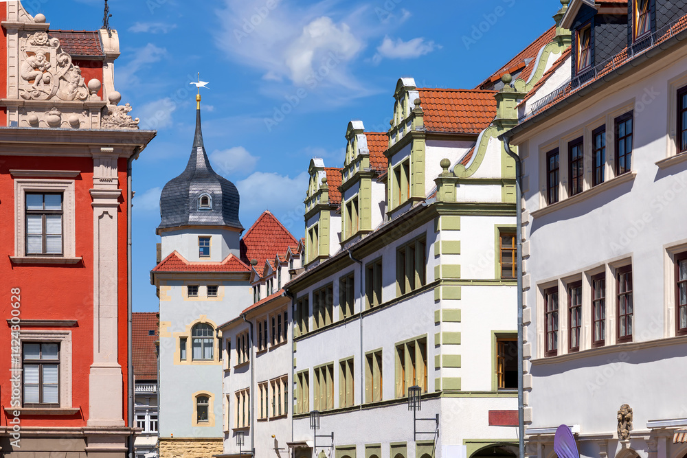 Colorful historic facades in Gotha, Germany, showcasing baroque and renaissance elements under a bright blue sky in summer light.