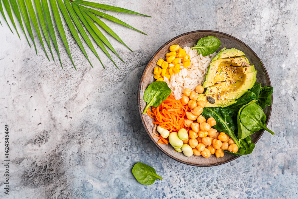 Poke bowl with spinach, avocado, corn, green salad, chickpeas, carrot and rice, blue background, top view. Concept of healthy eating, dieting