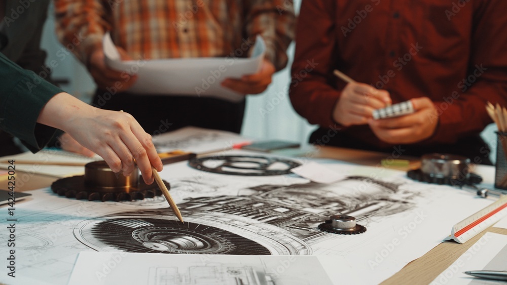 Obraz premium A diverse team collaborates on an engineering design, sketching detailed plans and illustrations on a table filled with tools and project papers in a professional workspace. SACTR