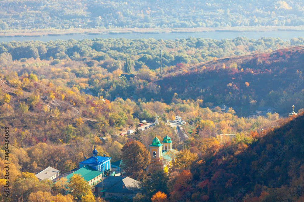 Aerial view of Saharna Monastery nestled in autumn forested hills, Moldova. Colorful domes and peaceful landscape create a serene spiritual retreat in nature embrace