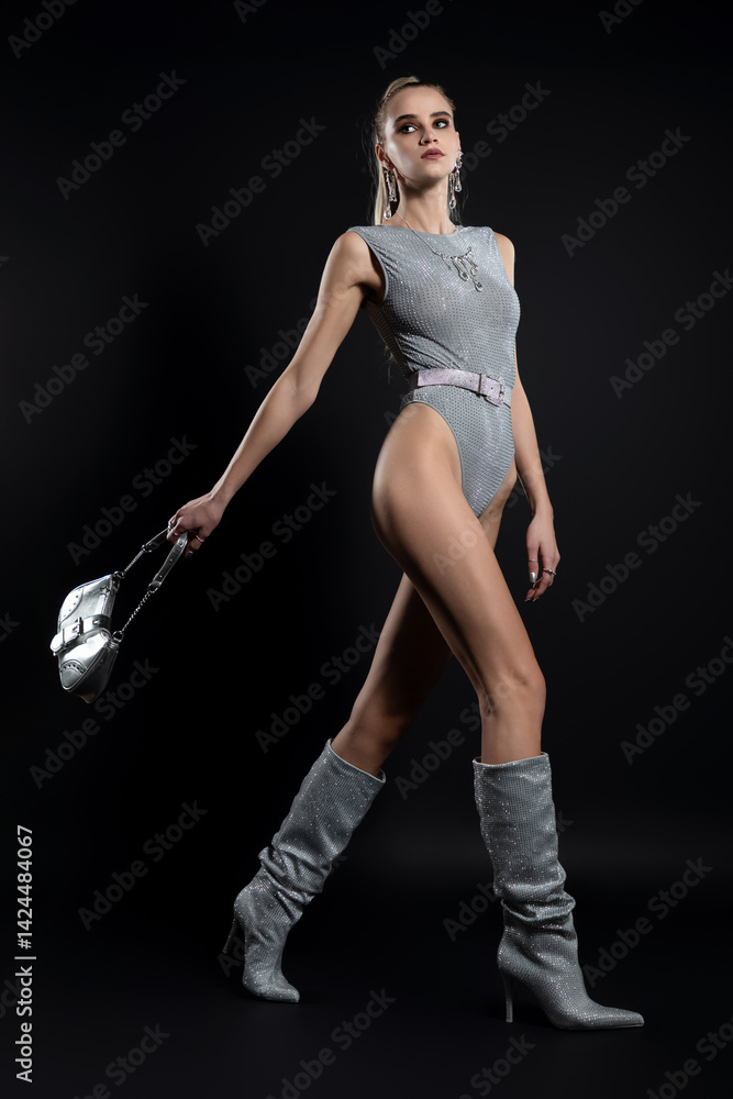 Fashion portrait of beautiful model in silver top and boots and silver jewelry