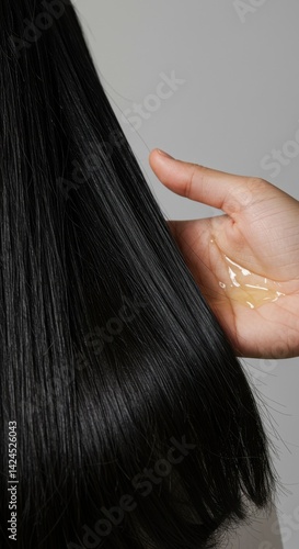 Applying hair oil to long shiny hair