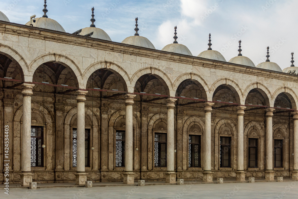 Fototapeta premium Capture the Mohammed Ali Mosque courtyard colonnade, showcasing alabaster art and Cairo Citadel view. Ideal for projects highlighting Islamic architecture and history.