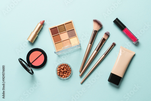 Obraz na płótnie Beauty products on blue background. Cosmetic palette, brushes, cream and lipsticks. Top view. w salonie