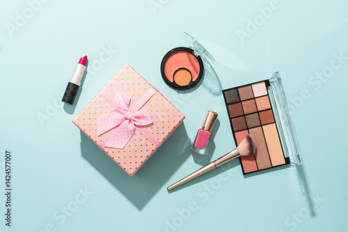 Beauty products on blue background. Cosmetic palette, brushes, cream and lipsticks. Top view.