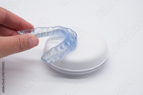 Doctor holding transparent dental night guard or mouthguard over its case