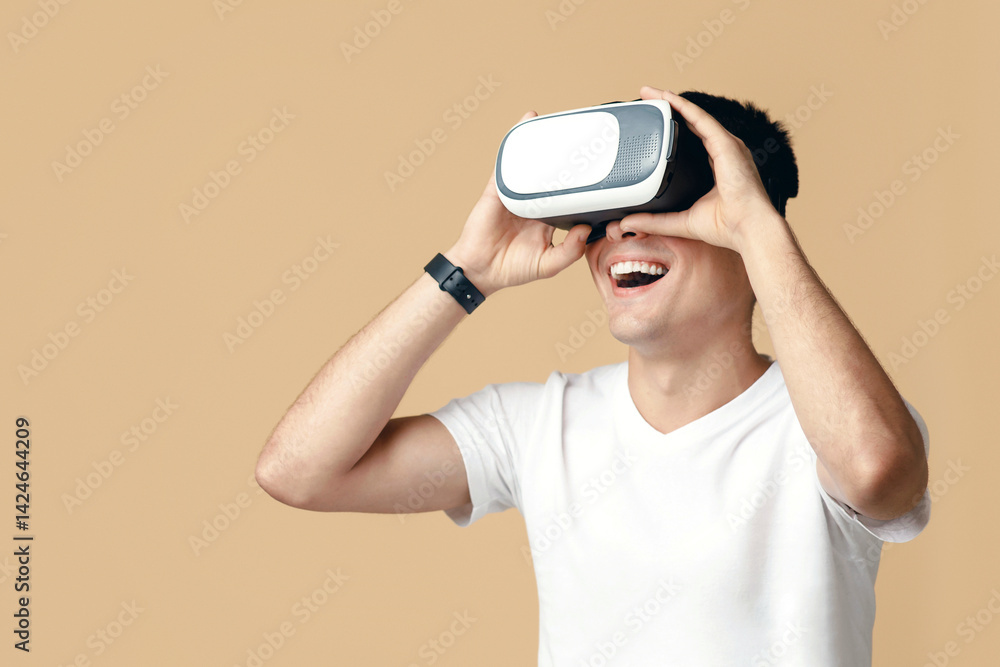 Virtual gadgets for entertainment, work, free time and study. Surprised happy guy student in white t-shirt uses vr glasses and looks at empty space, isolated on light background, studio shot Virtual gadgets for entertainment, work, free time and study. Surprised happy guy student in white t-shirt uses vr glasses and looks at empty space, isolated on light background, studio shot
