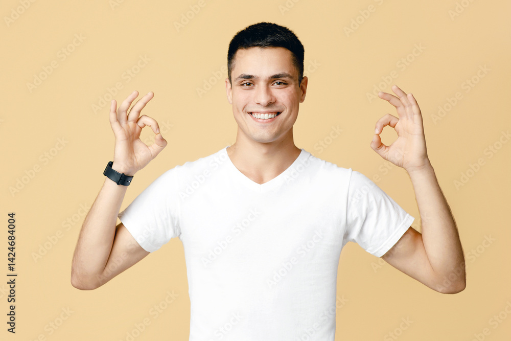 Great review, best offer, bloggers advice and advertisement. Attractive guy student in white t-shirt smiling and showing ok sign with hands, isolated on beige background, studio shot, free space Great review, best offer, bloggers advice and advertisement. Attractive guy student in white t-shirt smiling and showing ok sign with hands, isolated on beige background, studio shot, free space