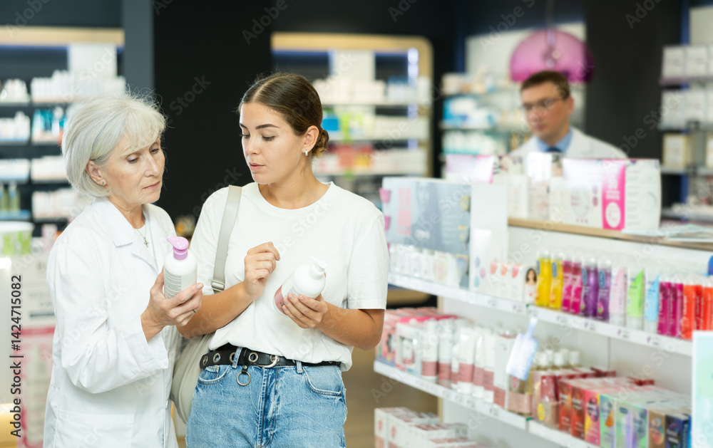 Obraz premium Girl buyer and an elderly woman pharmacist select intimate hygiene items together in a pharmacy