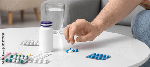 Man taking pills from table...