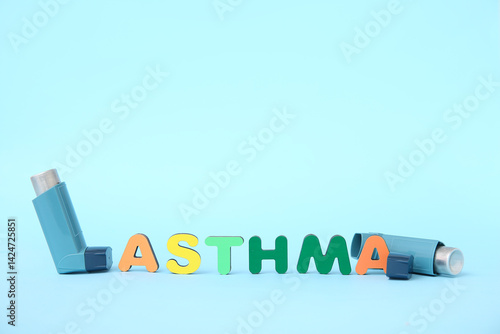 Word ASTHMA and inhalers on blue background